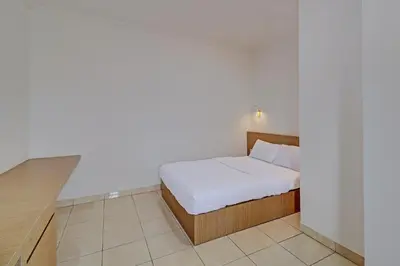 a small bedroom with a bed and a desk at Guest House Simalem in Legian