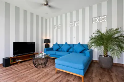 a living room with a blue couch and a tv at La Fortuna in Seminyak