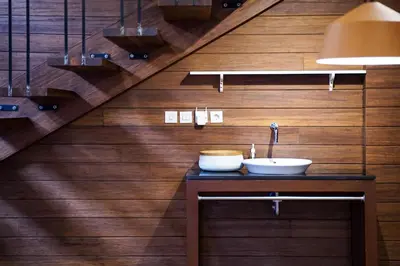 a bathroom with a sink on a wooden wall at Atra Bambulogy Villa by Bambulogy Resort in Kerobokan