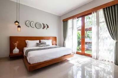 a bedroom with a bed and a large window at Villa Voyage 4 in Seminyak