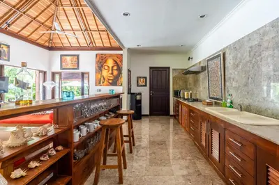 a kitchen with wooden cabinets and a counter with a sink at Madu Villa Seminyak in Seminyak