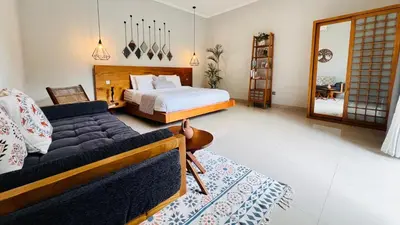 a bedroom with a bed and a couch at Villa Voyage 5 in Seminyak