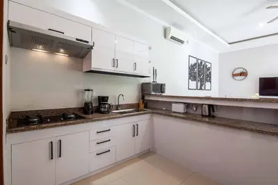 a kitchen with white cabinets and a counter top at Villa Voyage 5 in Seminyak