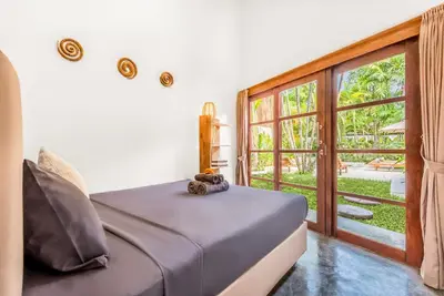 a bedroom with a bed and a large window at Villa Berlin - Private 6 BDR Villa in Seminyak with Pool and Garden in Seminyak