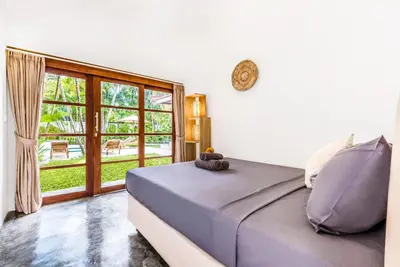 a bedroom with a bed and a large window at Villa Berlin - Private 6 BDR Villa in Seminyak with Pool and Garden in Seminyak