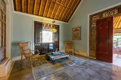 a living room with chairs and a table and a door at Villa Angsa by Nakula in Sanur