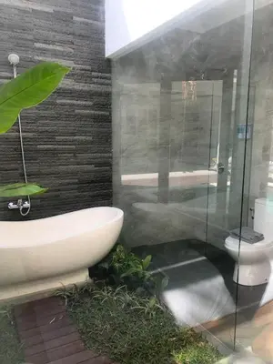 a bathroom with a glass shower and a toilet at Bali Villas Arta in Seminyak