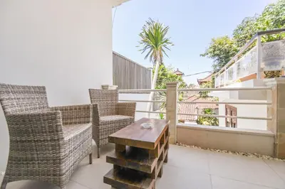 a balcony with chairs and a table on a balcony at Amalia Swan Haven Villa Seminyak in Seminyak