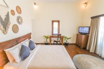 a bedroom with a large bed and a television at Amalia Swan Haven Villa Seminyak in Seminyak