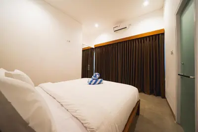 a bedroom with a white bed and a window at Umaja Villa in Seminyak