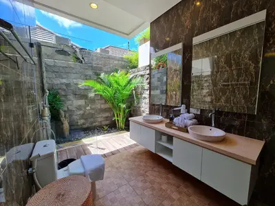 a bathroom with two sinks and a large mirror at Villa Kusamakura Seminyak in Seminyak