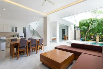 an open living room and dining room with a table and chairs at Villa Kusamakura Seminyak in Seminyak