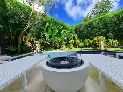 a pool with a fire pit in the middle of a yard at Villa Kusamakura Seminyak in Seminyak