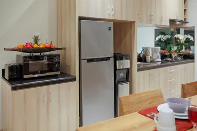 a kitchen with a stainless steel refrigerator and a table at Villa 66, 5 min walk to Double 6 beach in Seminyak