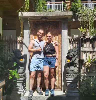 a man and a woman standing in front of a door at Genta House in Kuta