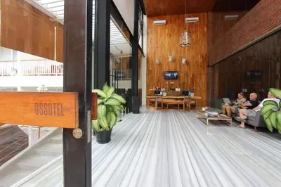 a lobby with people sitting in chairs in a building at Ossotel Legian in Legian