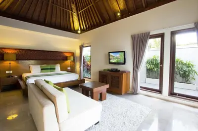 a bedroom with a bed and a couch at Serene Villas in Seminyak