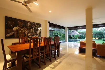 a dining room with a wooden table and chairs at Serene Villas in Seminyak
