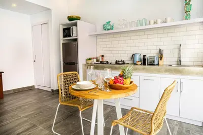 a kitchen with a table with a bowl of fruit on it at Casa Su Seminyak in Seminyak