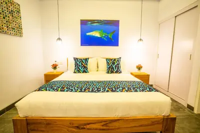 a bedroom with a bed with a fish painting on the wall at Casa Su Seminyak in Seminyak
