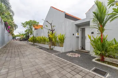 a street with a white building and some plants at Casa Nisa Seminyak in Seminyak