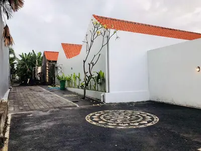 a white building with a circle in front of it at Casa Ku Seminyak in Seminyak