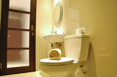 a bathroom with a toilet and a sink at Kuta Sari House in Kuta