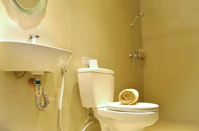 a bathroom with a toilet and a sink at Kuta Sari House in Kuta