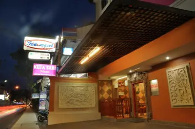 a building with signs on the side of a street at Kuta Sari House in Kuta