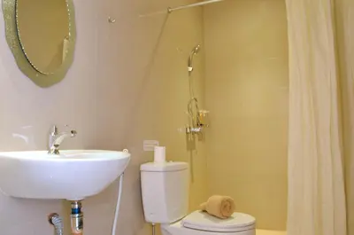 a bathroom with a sink and a toilet and a shower at Kuta Sari House in Kuta