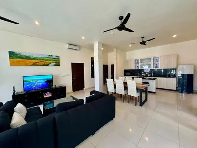 a living room with a couch and a dining room at Saga Villas Legacy in Seminyak