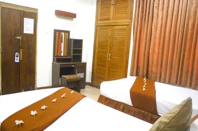 a hotel room with two beds and a mirror at Troppo Zone Puri Rama Resort Kuta in Legian