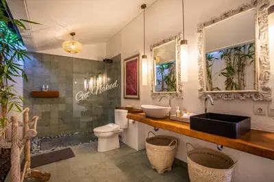 a bathroom with a sink and a toilet at PinkPrivate Sanur - for Cool Adults Only in Sanur