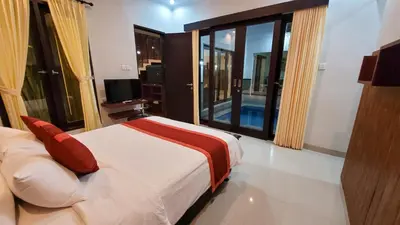 a bedroom with a bed and a large window at Ramantika Sunset Bay in Nusa Dua