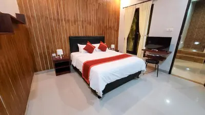 a bedroom with a bed with red pillows and a piano at Ramantika Sunset Bay in Nusa Dua
