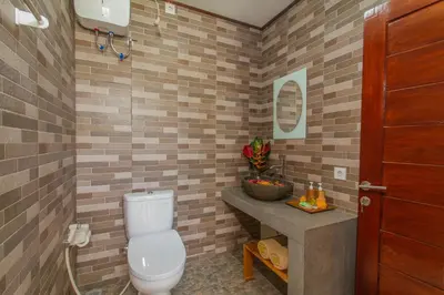 a bathroom with a toilet and a sink at Mailaku House in Kerobokan