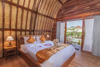 a bedroom with a bed with a teddy bear on it at Mailaku House in Kerobokan
