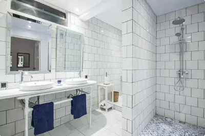 a white bathroom with two sinks and a mirror at Villa Alexandra Seminyak By Island Escape in Seminyak