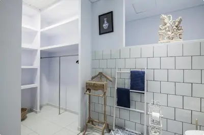 a bathroom with white tiles on the wall at Villa Alexandra Seminyak By Island Escape in Seminyak