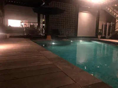 a swimming pool at night in a building at Rumah Kahyangan in Canggu