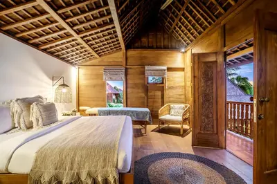 a bedroom with a large bed and a balcony at Villa Nabi by Alfred in Bali in Seminyak
