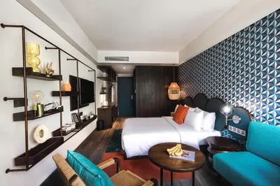 a hotel room with a bed and a couch at MAMAKA by Ovolo in Kuta