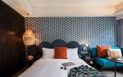 a bedroom with a large bed and a couch at MAMAKA by Ovolo in Kuta