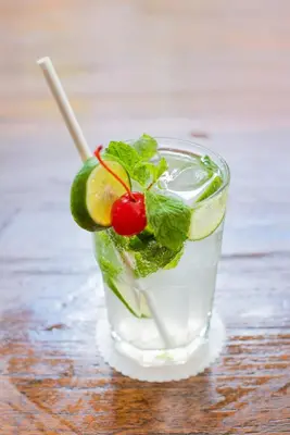 a glass of water with a drink with a cherry and mint at Aldeoz Grand Kancana Villas Resort Bali in Kerobokan