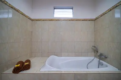 a bath tub in a bathroom with a pair of shoes at Villa Devina - Seminyak in Seminyak