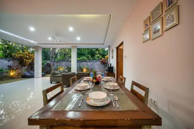 a dining room with a wooden table and chairs at Villa Devina - Seminyak in Seminyak