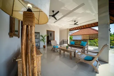 a living room with a ceiling fan and chairs at Villa Devina - Seminyak in Seminyak