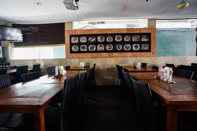 a dining room with wooden tables and chairs at Taman Ayu Legian Hotel in Legian
