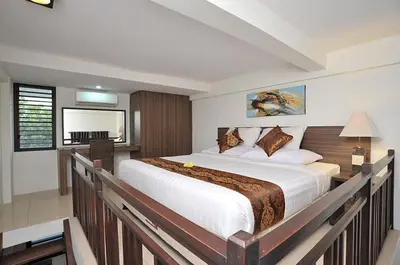 a bedroom with a large bed and a desk at Ganga Hotel & Apartment in Denpasar