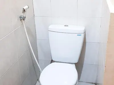 a white toilet in a bathroom with a hose at KoolKost at Poppies Lane Street - Minimum stay 30 nights in Denpasar